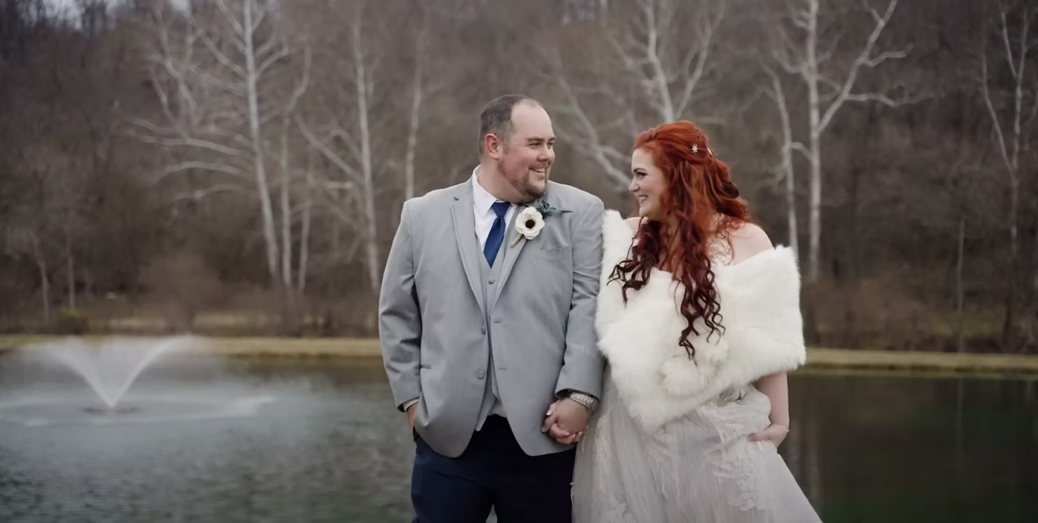 Bride and groom standing together by a fountain