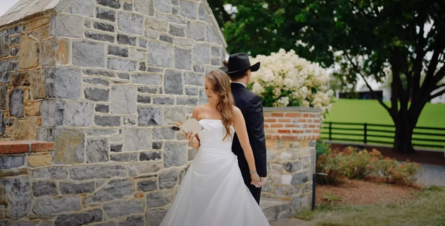 Bride and groom against a rustic stone wall