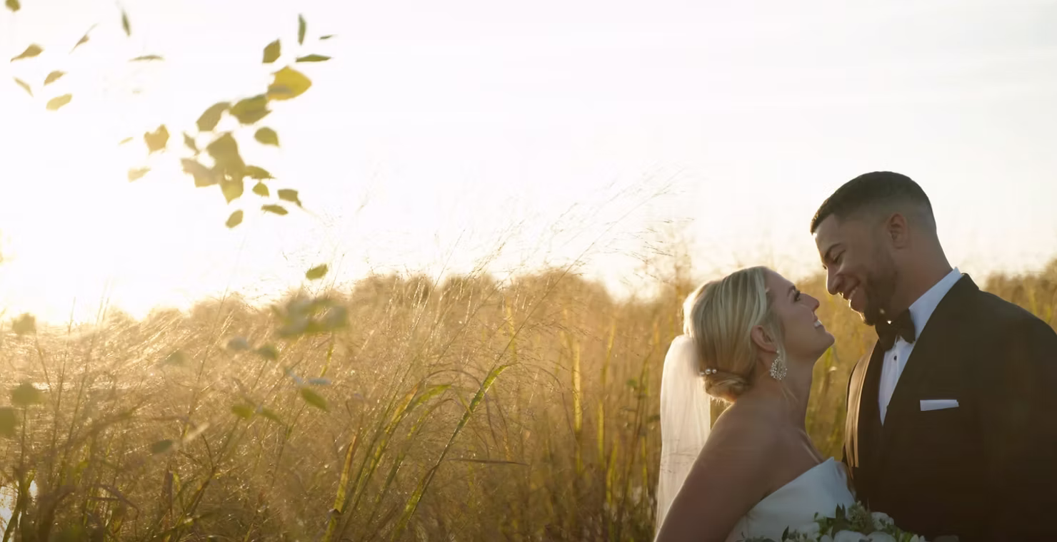 Bride and groom standing together in a golden field