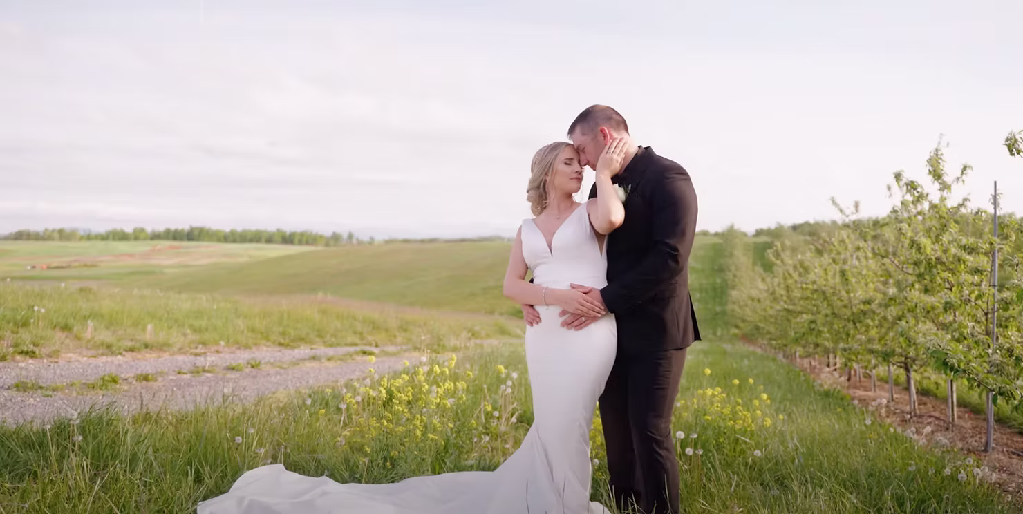 Bride and groom kiss amid open farmland