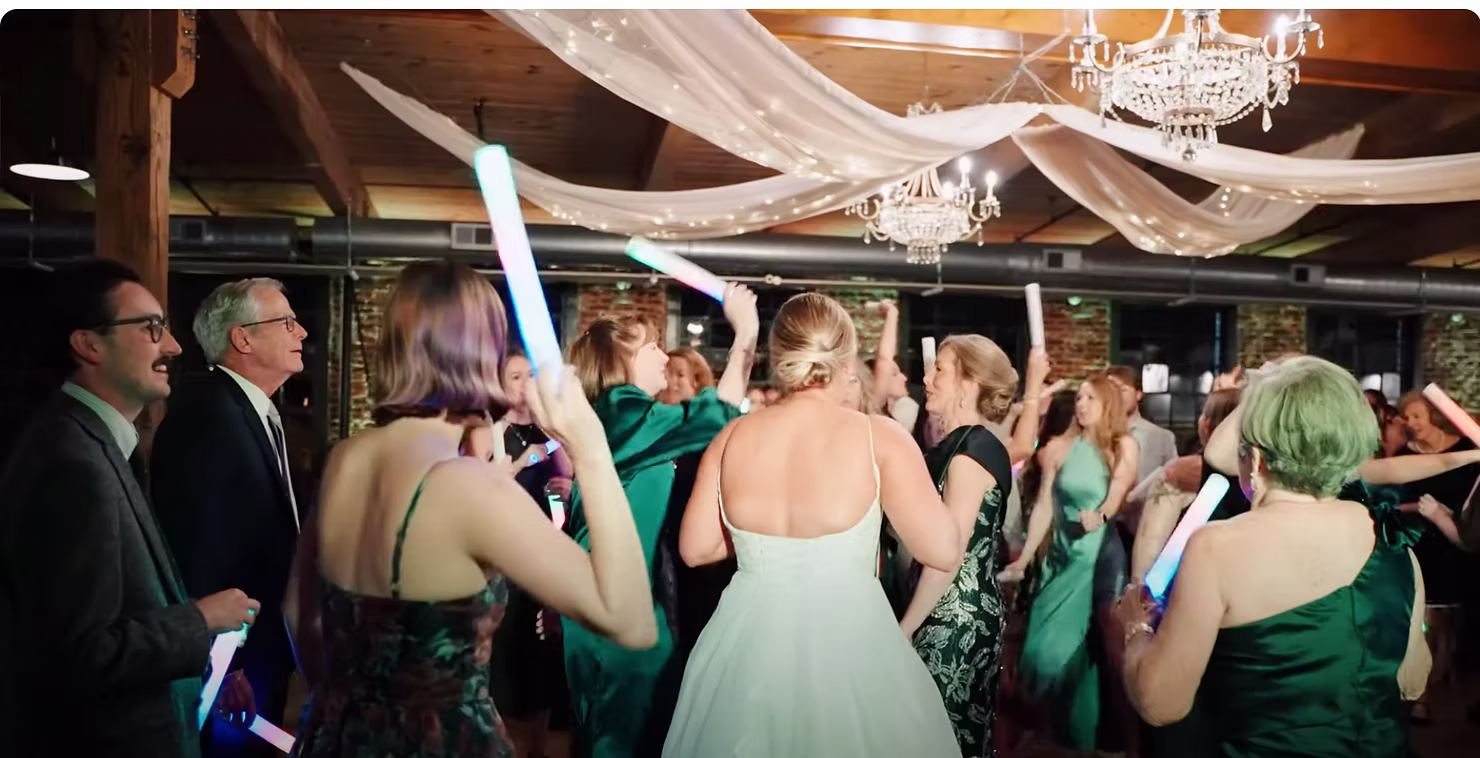 Wedding guests dancing under a draped-ceiling barn reception