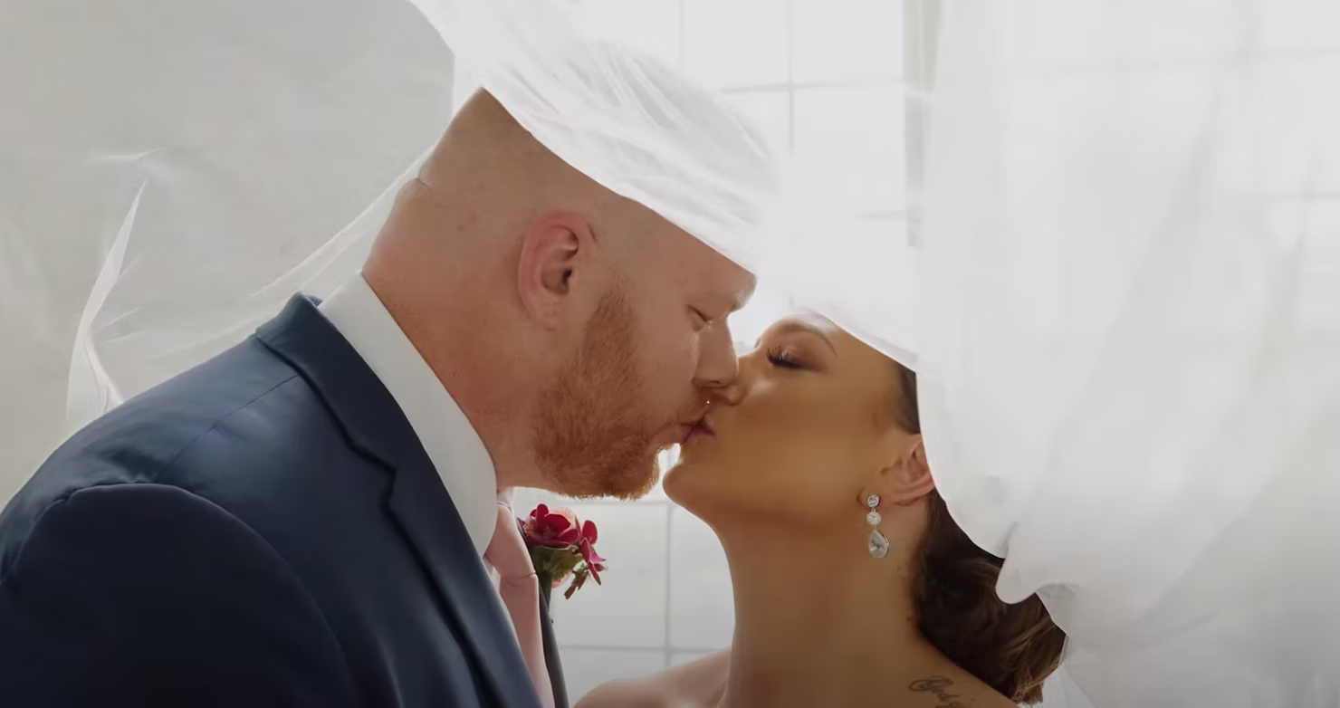 Bride and groom share a kiss during their wedding ceremony